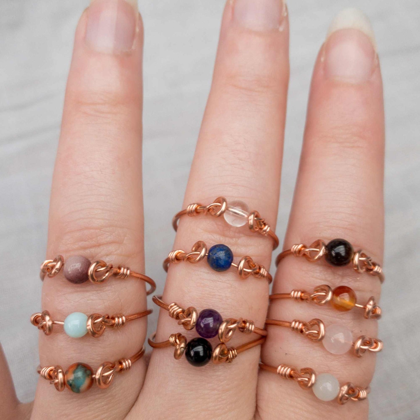 hand showing rings in different crystals